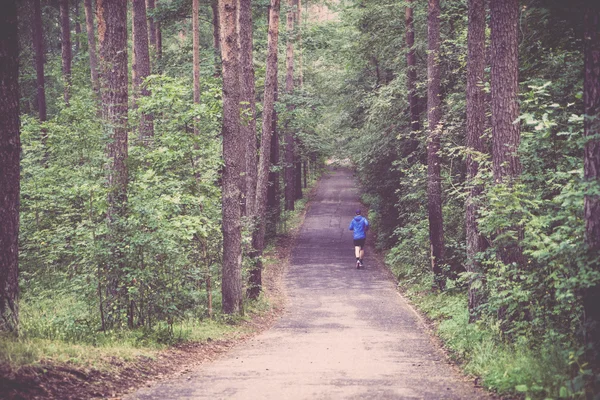 Чоловіки бігають у синьому пальто в лісі ретро, вінтаж — стокове фото