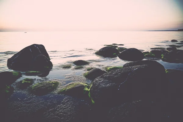 Rotsachtig strand bij zonsondergang met melkachtig water - retro, vintage — Stockfoto