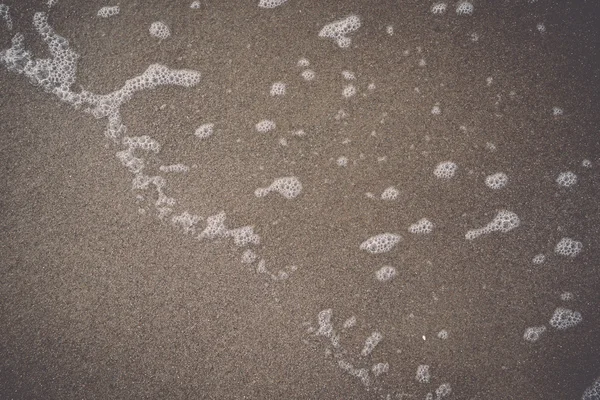 Water waves rushing in sand - retro, vintage — Stock Photo, Image