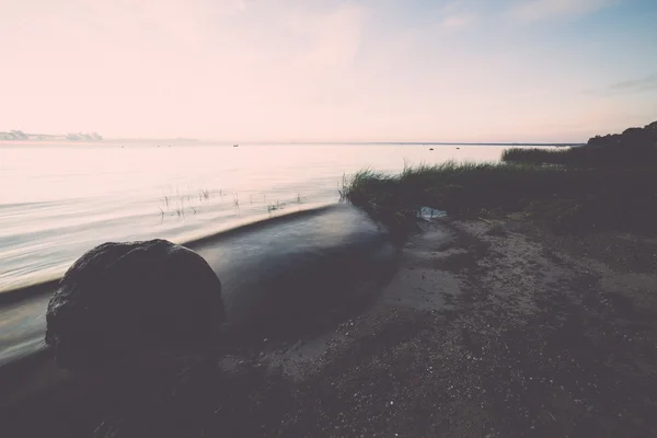 Hermoso amanecer en el mar en la playa salvaje - retro, vintage —  Fotos de Stock