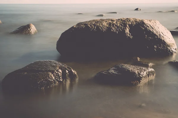 Weergave van een rotsachtige kust in de ochtend. Lange blootstelling schot. -retr op te geven — Stockfoto