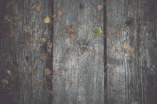 Vecchie tavole di legno ricoperte di foglie retrò, vintage — Foto Stock