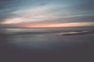 uzun pozlama ile dramatik mavi günbatımı dalgaları - retro yıkanmış