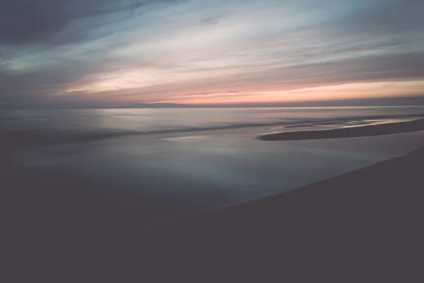 Long exposure dramatic blue sunset with washed out waves - retro — Stock Photo, Image