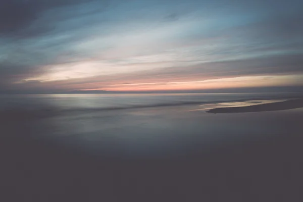 Lång exponering dramatiska blå solnedgången med urblekta vågor - retro — Stockfoto