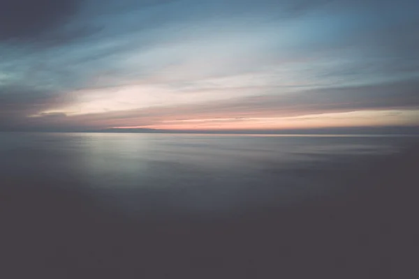 Long exposure dramatic blue sunset with washed out waves - retro — Stock Photo, Image
