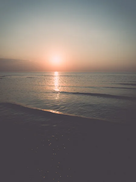 Barevný západ slunce v moři s odrazy a mraky - retro, — Stock fotografie