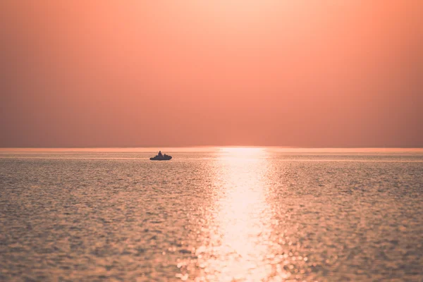 Barco al atardecer en el mar con reflejos y nubes - retr — Foto de Stock