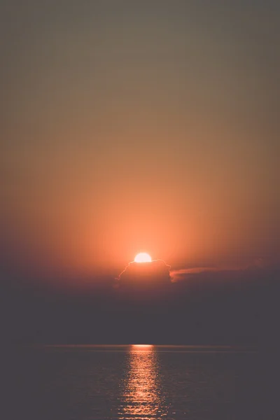 Farbenfroher Sonnenuntergang im Meer mit Reflexionen und Wolken - retro, — Stockfoto