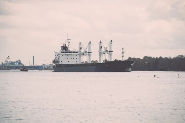 Buque de carga está saliendo del puerto navegando lejos - retro, vintage —  Fotos de Stock