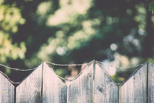 Alter Holzzaun mit Stacheldraht drauf - retro, vintage — Stockfoto