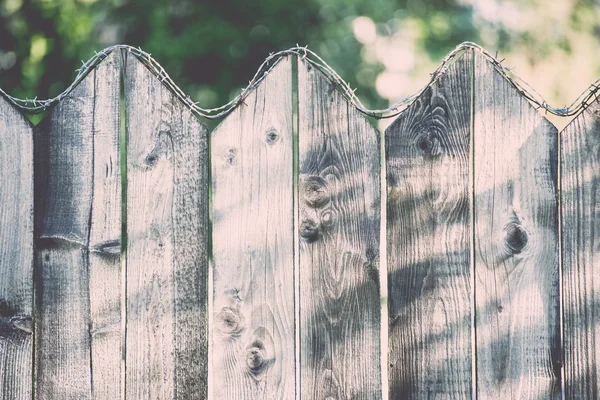 Alter Holzzaun mit Stacheldraht drauf - retro, vintage — Stockfoto