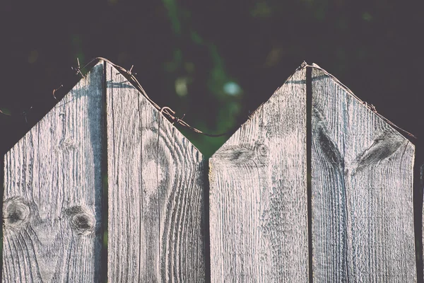 Cerca de madera vieja con alambre de púas en la parte superior - retro, vintage —  Fotos de Stock