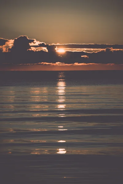 Schöner Sonnenaufgang im Meer am wilden Strand - retro, vintage — Stockfoto