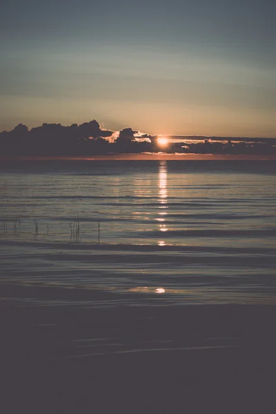 Hermoso amanecer en el mar en la playa salvaje - retro, vintage —  Fotos de Stock