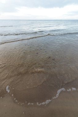 bulutlar ve ıssız dune doğru dalgalar ile sonbaharda Baltık beach
