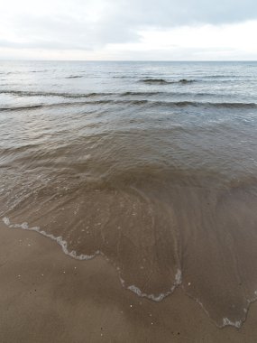 bulutlar ve ıssız dune doğru dalgalar ile sonbaharda Baltık beach