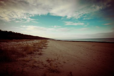 bulutlar ve ıssız dune doğru dalgalar ile sonbaharda Baltık beach