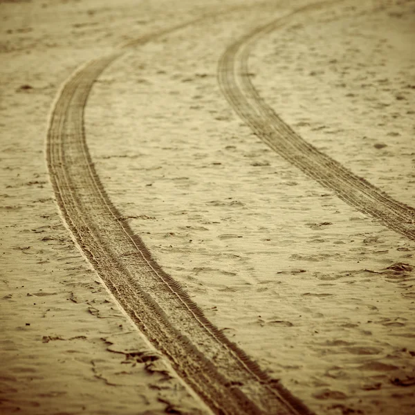 Faixas de pneus de carro na areia da praia - look vintage retro — Fotografia de Stock