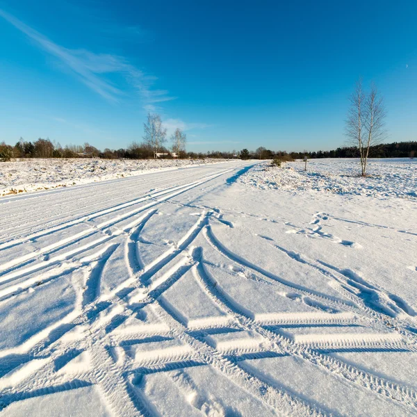 Снежная зимняя дорога с маркировкой шин — стоковое фото