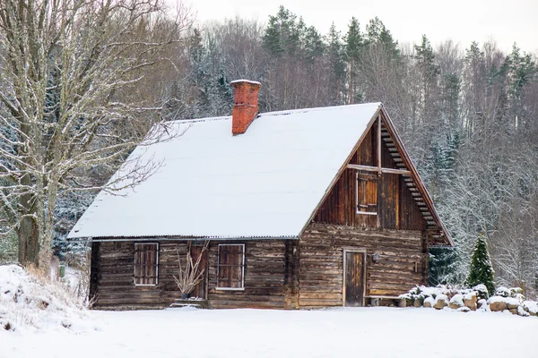 Besneeuwde winter forest landschap met sneeuw bedekte huis — Stockfoto