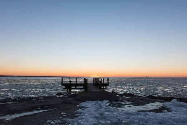 Coucher de soleil sur la mer gelée avec vieux pont métallique — Photo