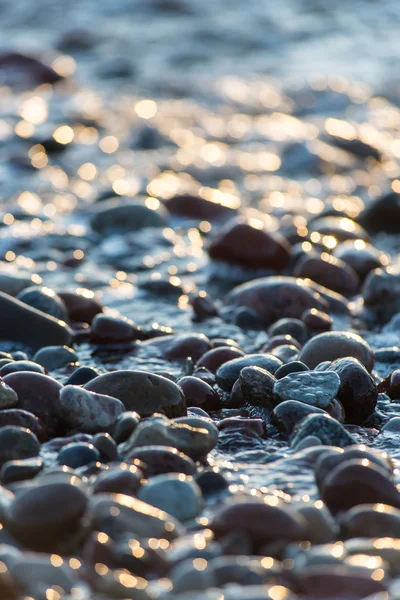 Камни на пляже и морская вода — стоковое фото