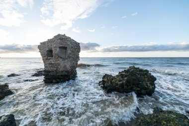 Dalgalar kayaların üzerinden'nde Günbatımı kırma