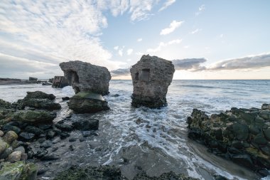 Dalgalar kayaların üzerinden'nde Günbatımı kırma