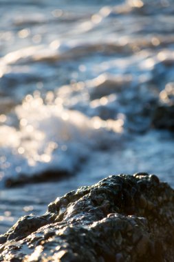 Dalgalar kayaların üzerinden'nde Günbatımı kırma