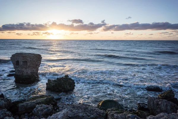 Onde che si frantumano sulle rocce al tramonto — Foto Stock