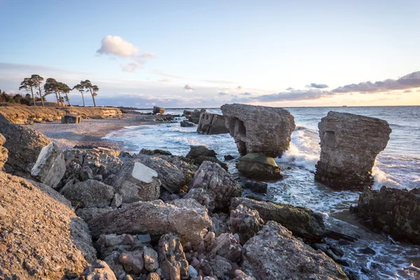 Onde che si frantumano sulle rocce al tramonto — Foto Stock