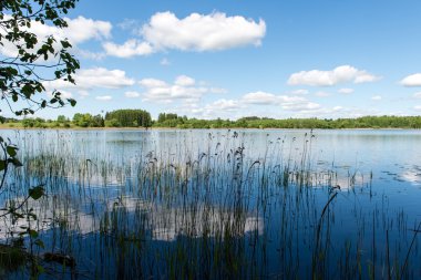 Beyaz bulutların üstünde mavi göl üzerinde mavi gökyüzü