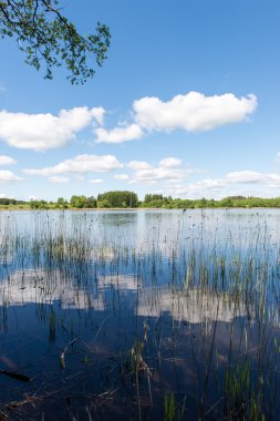 Beyaz bulutların üstünde mavi göl üzerinde mavi gökyüzü