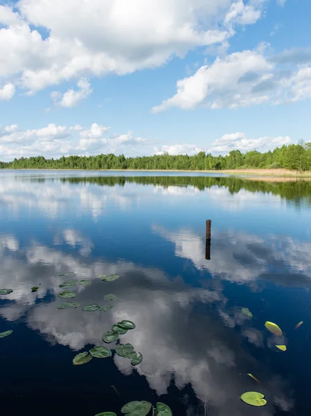 Nubes blancas en el cielo azul sobre el lago azul — Foto de Stock