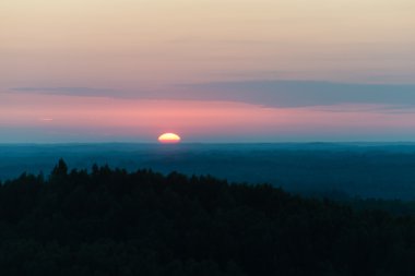 Karanlık ormanın üzerinde dramatik gündoğumu