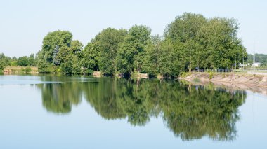 Sakin göl kenarında simetrik yansımalar