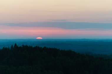 Karanlık ormanın üzerinde dramatik gündoğumu