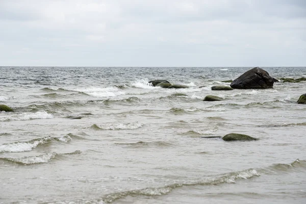 Praia de outono rochosa com ondas batendo nas rochas — Fotografia de Stock