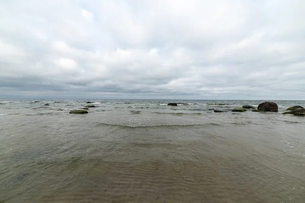 Praia de outono rochosa com ondas batendo nas rochas — Fotografia de Stock