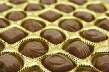 Açık bir kutuya koyulmuş çikolata şekerlemeleri. Çikolata şekeri yakın plan. Çeşitli çikolatalı tatlılar..  