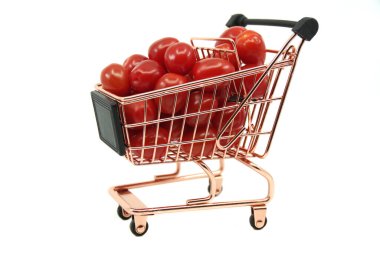 Beyaz arka planda kırmızı kiraz domatesli mini araba. Alışveriş ve yiyecek alışverişi metafor konsepti.