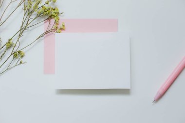 Beyaz arkaplanda beyaz davetiye, Noel ve kutlama sezonu konsepti için tebrik kartı fikirlerinin üst görüntüsü.