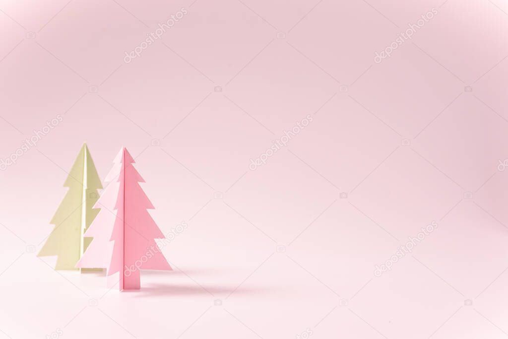 Christmas background ideas with handicraft of colour paper cut in the shape of a Christmas tree on pink background blank space in the right side,copy space concept.