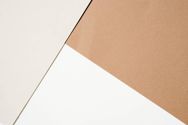 Сливочная цветная бумага, помещенная на белую бумагу и крафт бумагу для фона.