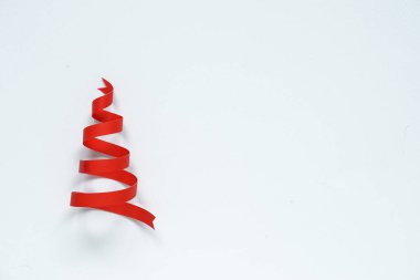 Kırmızı kurdele kağıdından yapılmış Noel ağacı boş beyaz arka planda fotokopi alanı ile birlikte..