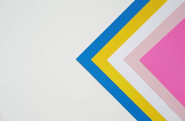Geometrik desende renkli kağıtların istiflenmesi ile soyut arka plan kavramı, beyaz arkaplanda boş pembe kağıt katmanları ve beyaz, sarı, mavi renk.