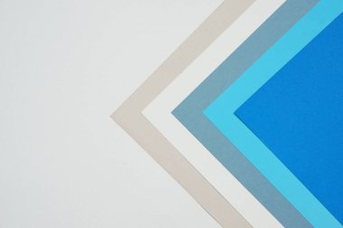 Geometrik desende renkli kağıtların istiflenmesi ile soyut arkaplan kavramı, beyaz arkaplanda mavi kağıt ve krem renkli kağıtların çeşitli katmanları.