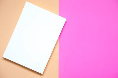 Pembe kağıda yerleştirilmiş dikey beyaz kağıdın üst görünümü ve eski gül rengi kağıt arka plan, düz yatıyordu.