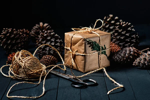 Caja Regalo Envuelta Papel Kraft Tijeras Cuerda Piñas Sobre Madera — Foto de Stock